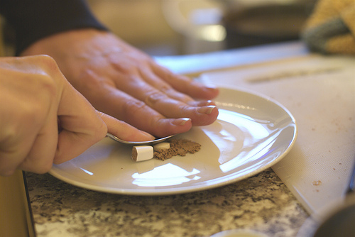Man preparing natural remedies on a rounded white plate